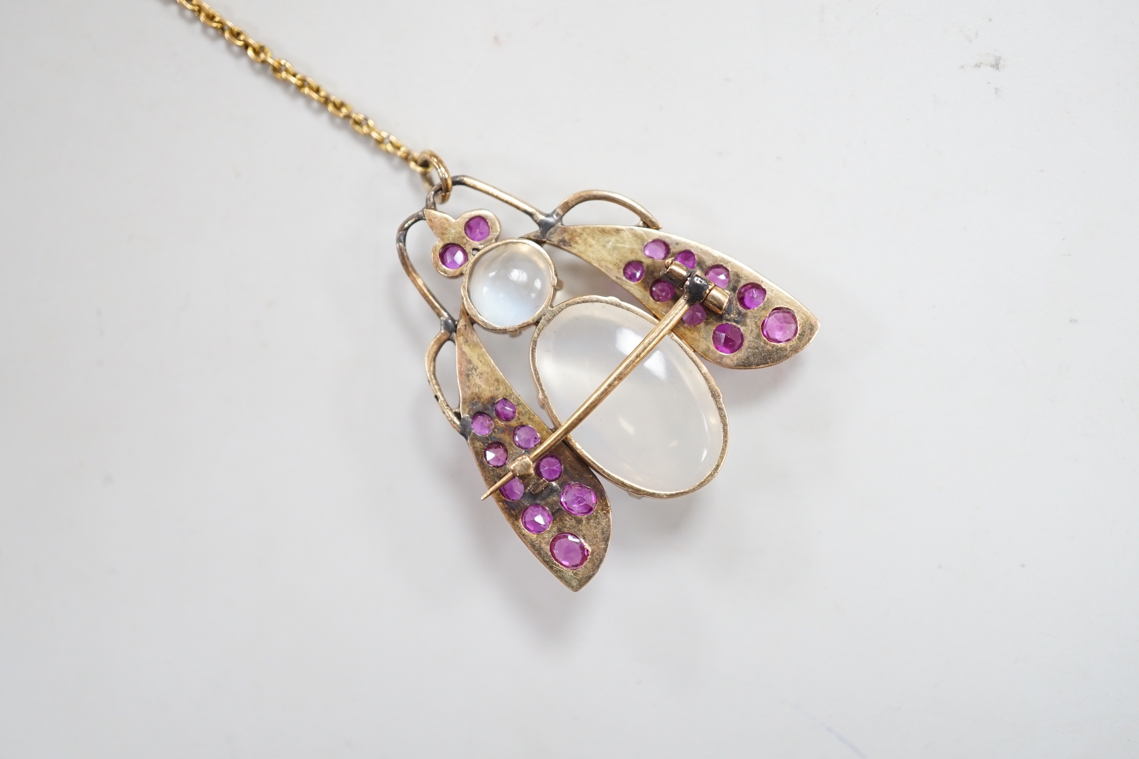 A yellow metal moonstone and ruby cluster set bug brooch, 27mm, gross weight 4.9 grams.